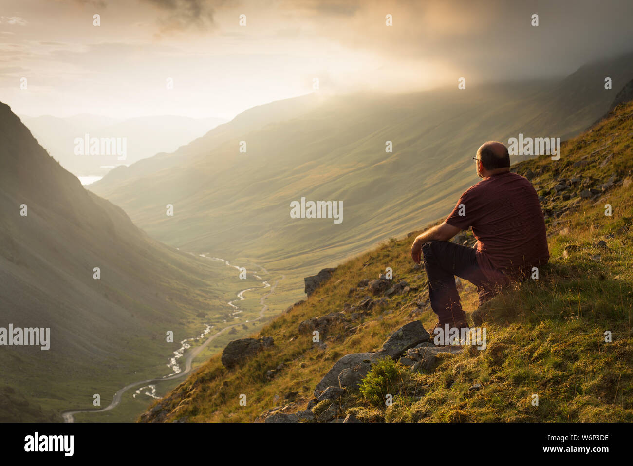 Ein Mann blickt auf honister Pass in der North Western Fells des Lake District, Großbritannien Stockfoto