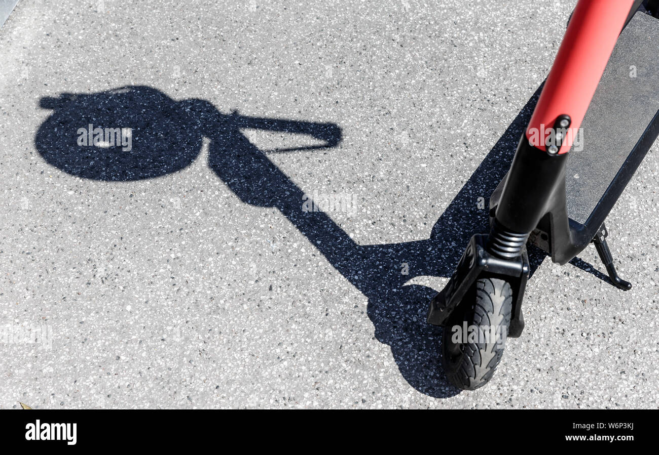 Hamburg, Deutschland. 23. Juli, 2019. Der Schatten eines Herlmes auf dem Griff eines elektrischen Pedal Roller kann an einer Vermietstation gesehen werden. Quelle: Markus Scholz/dpa/Alamy leben Nachrichten Stockfoto