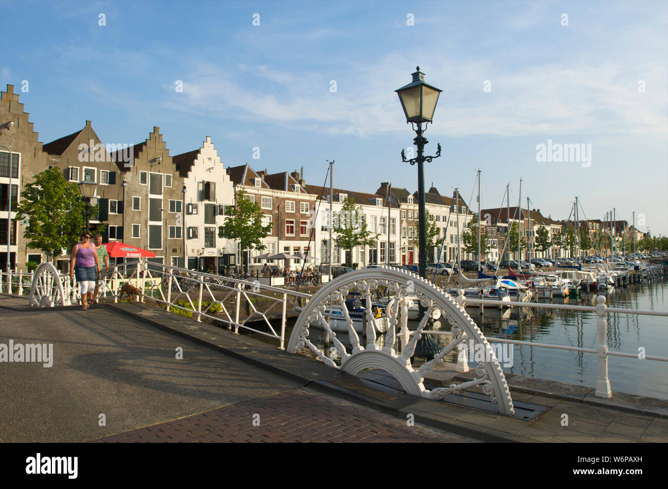 Ein paar gehen der Hund am Kinderdijk und die spijker Brücke mit historischen Gebäuden in der Stadt Middelburg, Niederlande Stockfoto