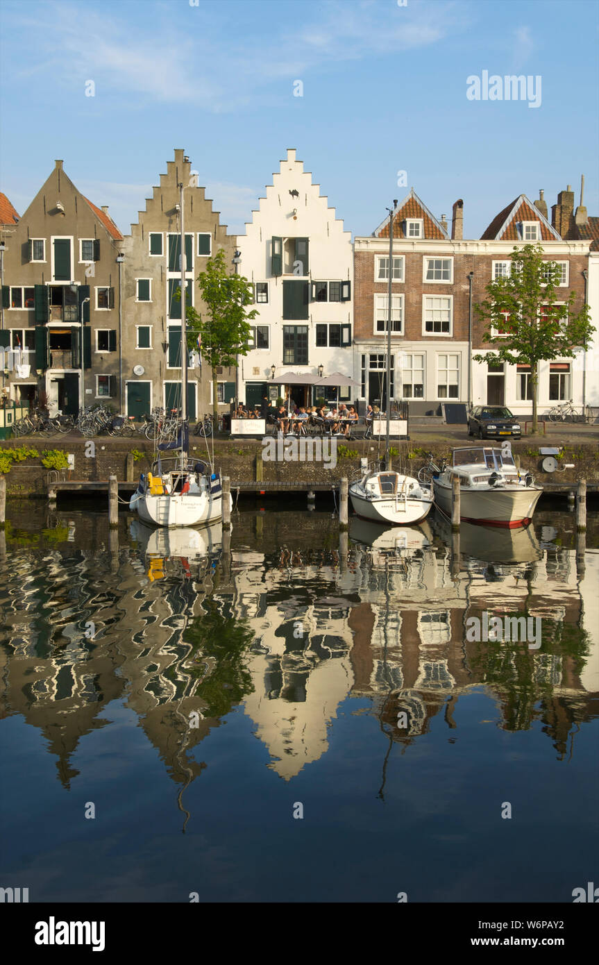Die kinderdijk mit historischen Gebäuden und Menschen in einem Cafe sitzen in der Stadt Middelburg, Niederlande Stockfoto