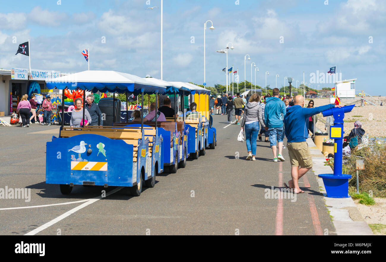 Menschen Reiten auf der Noddy Zug entlang der Strandpromenade in Littlehampton, West Sussex, England, UK. Stockfoto