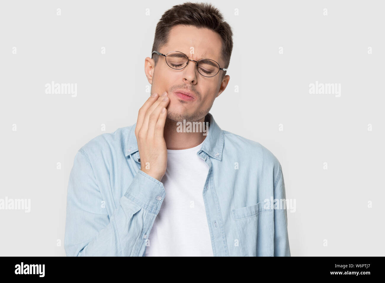 Headshot studio Porträt Mann in Gläsern leidet unter Zahn Ache Stockfoto