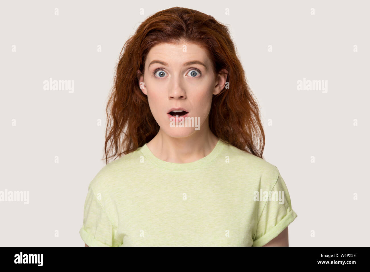 Headshot studio Portrait redhead verängstigte Frau macht große Augen Stockfoto