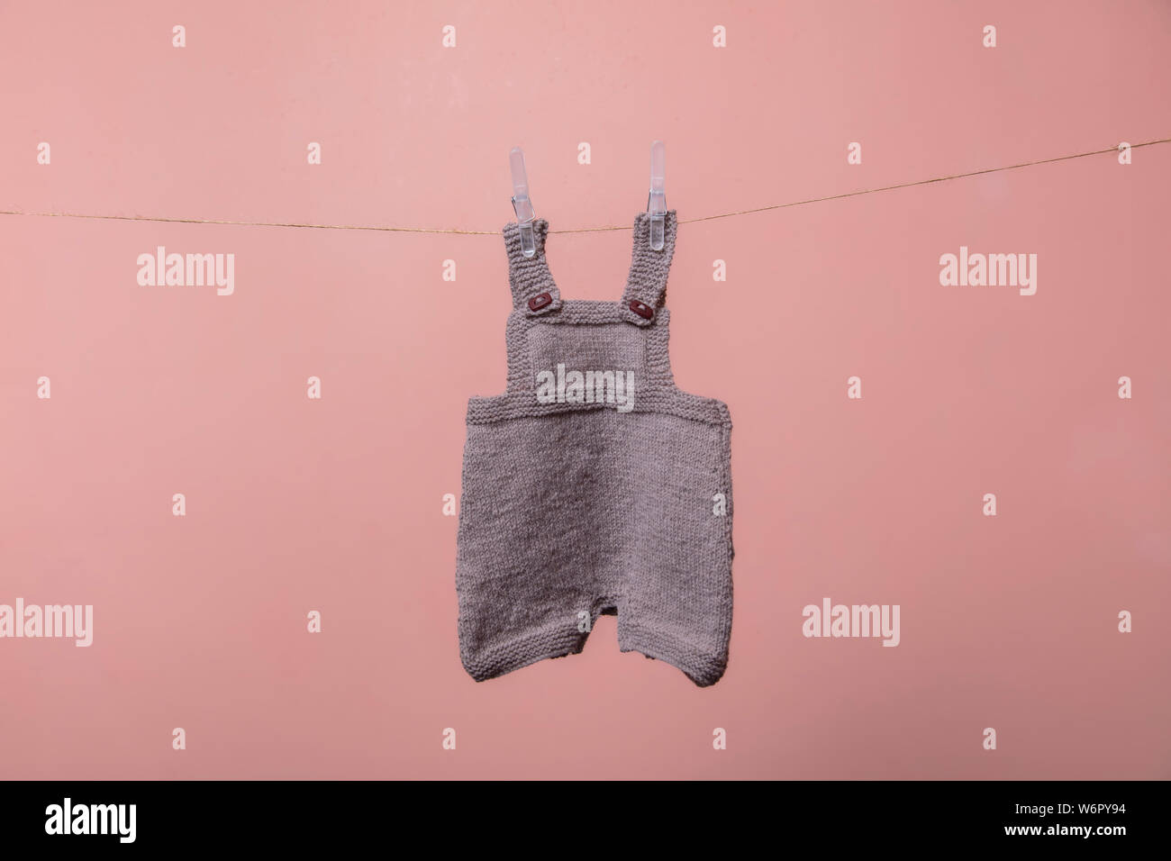 Handarbeit gestrickte Baby Kleidung hängend auf einer Linie Stockfoto