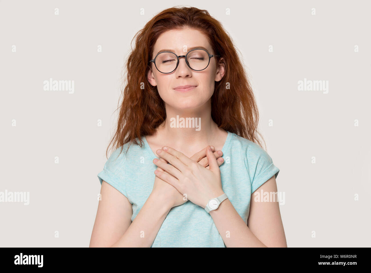 Frau schließen ihre Augen hält die Hände auf der Brust fühlt sich Dankbarkeit Stockfoto