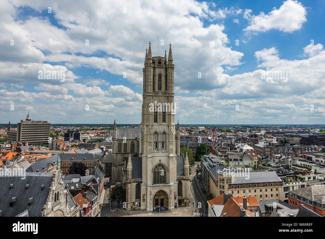Gent, Flandern, Belgien - 21. Juni 2019: Aufnahme von oben Belfry. Sint-Baafs Cathedral und Nahaufnahme der Turm gegen den blauen Himmel mit CLOUDSCAPE. Stadtbild Stockfoto