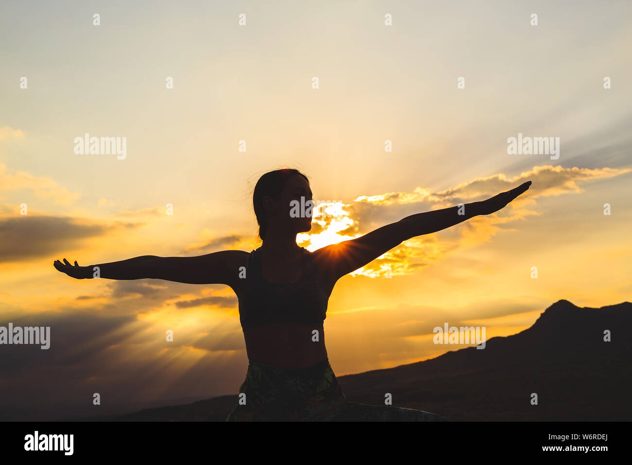 Silhouette der jungen Frau Üben Yoga oder pilates bei Sonnenuntergang oder Sunrise in wunderschöner Lage, ausfallschritt Übung, stehend im Krieger Stockfoto