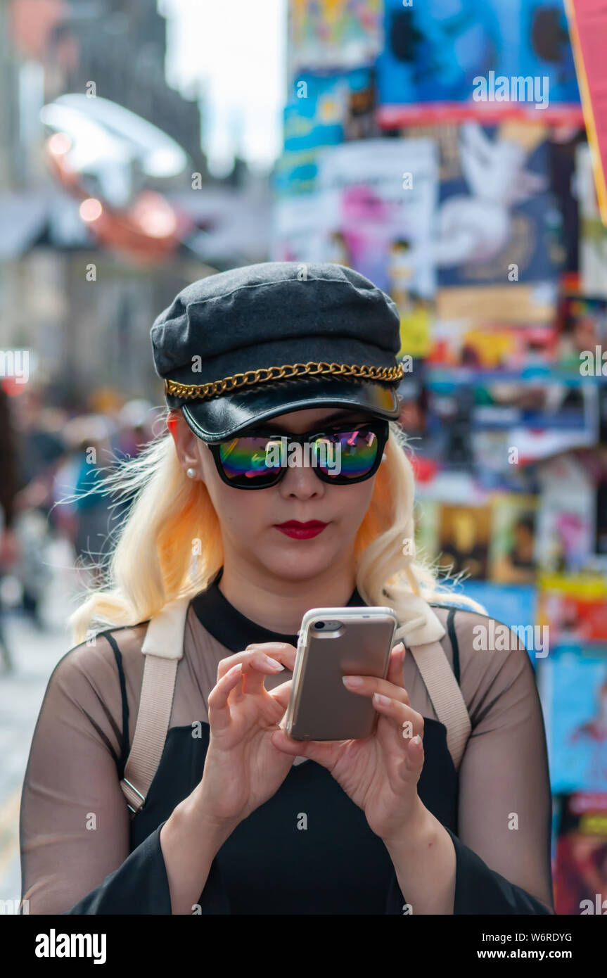 Edinburgh, Schottland, Großbritannien. 2. August 2019. Ein Mädchen auf der Royal Mile Kontrolle ihr Mobiltelefon zu Beginn des Edinburgh Fringe Festival. Credit: Skully/Alamy leben Nachrichten Stockfoto