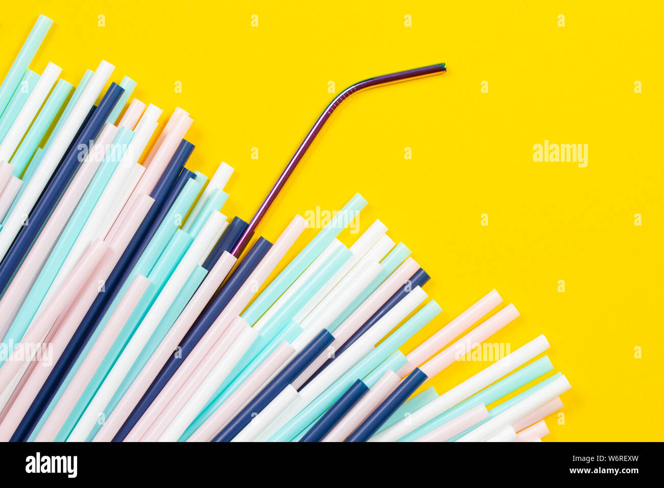 Edelstahl wiederverwendbare Trinkhalm mit vielen bunten Plastik Strohhalme auf gelbem Hintergrund Stockfoto