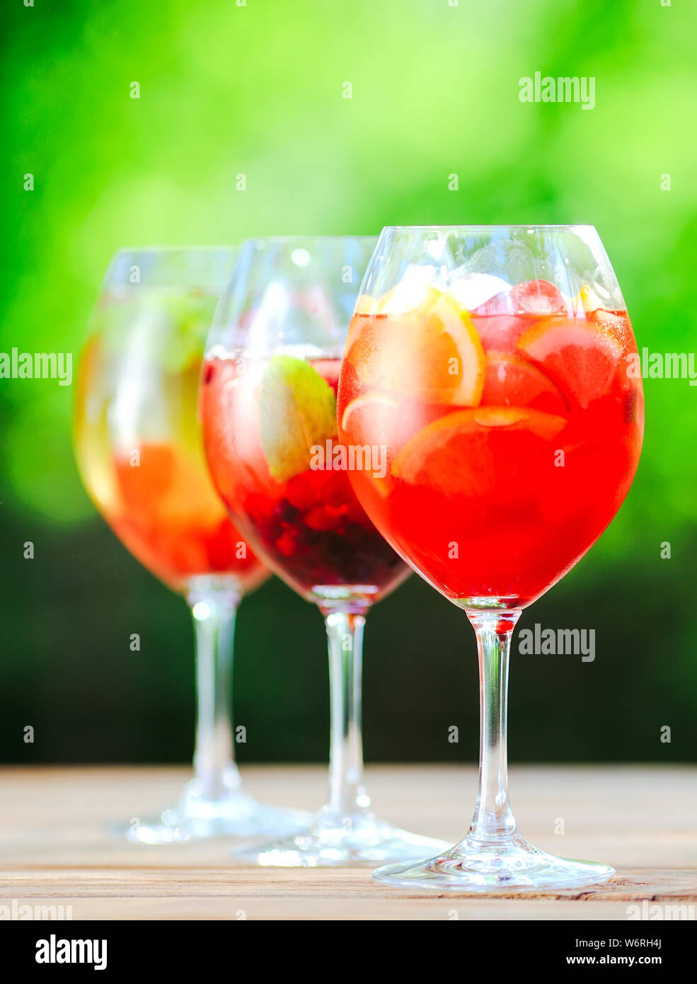 Sommer Cocktail. Fruchtcocktail auf grünem Hintergrund. Zitrusfrüchte, Beeren, Erdbeeren, Heidelbeeren, Minze, Eis Stockfoto