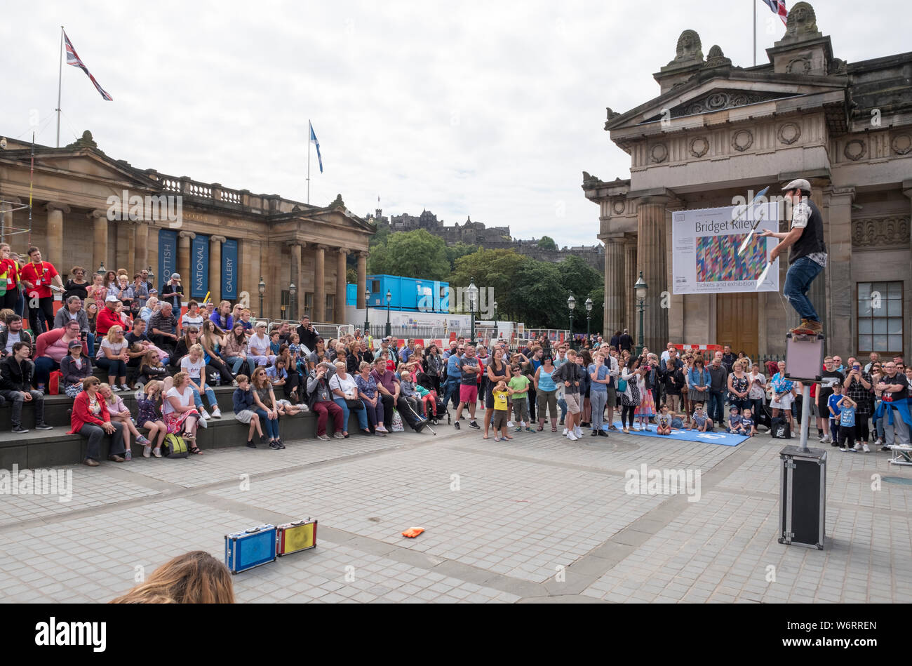 Ein Straßenkünstler unterhält die Menge auf dem Mound in Edinburgh Teil des Edinburgh Festival Fringe, das größte Kunstfestival der Welt. Stockfoto