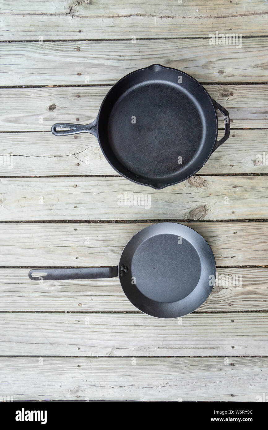 Traditionelle Gusseisen vs Carbon Steel versus Teflon kochen Optionen - Leeren leeren Raum für Text oder kopieren. Zwei Kochgeschirr Stücke - Küche Herd zu Stockfoto