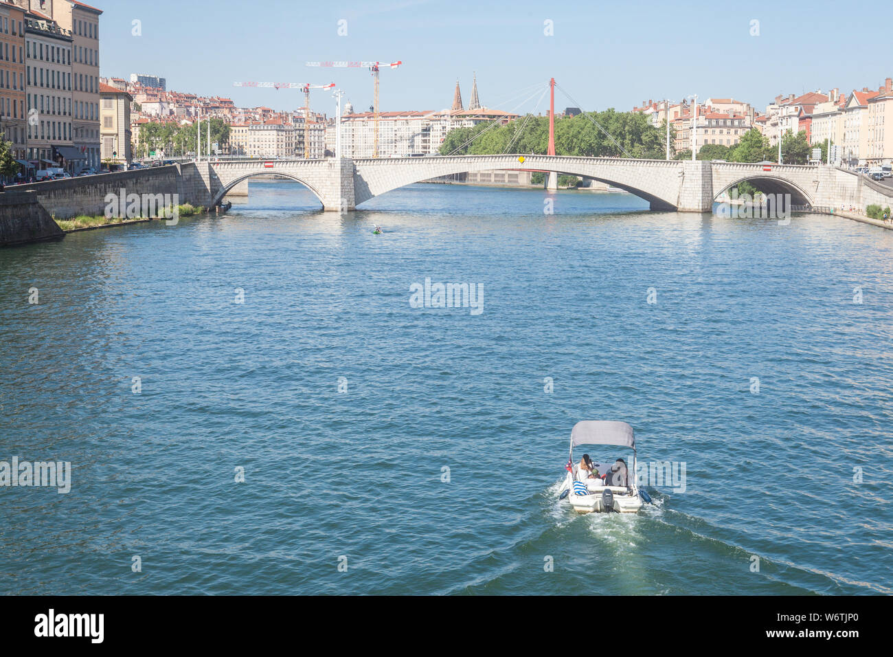 LYON, Frankreich - Juli 19, 2019: Boot nähert sich Pont Bonaparte Brücke der Saone Fluss in der Nähe des Quais de Saone Ufer und Fluss im Stadtzentrum Stockfoto