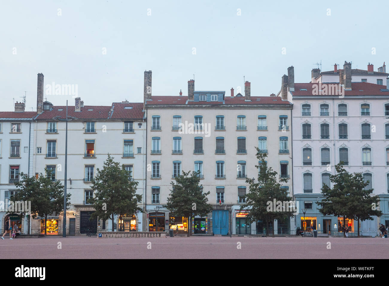 LYON, Frankreich - 17. JULI 2019: Traditionelle französische Gehäuse Gebäude mit Fassaden aus dem 19. Jahrhundert am Place Bellecour Square, ein touristisches Wahrzeichen der Ci Stockfoto