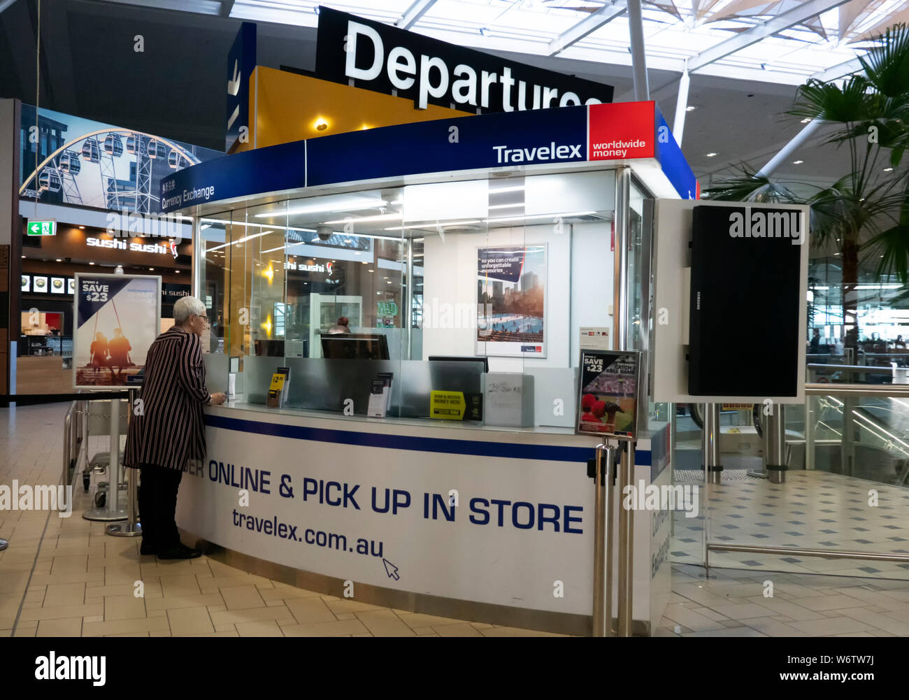 Dame Reisender den Austausch von Währungen am Travelex Desk am Flughafen Brisbane, internationalen Terminal, Queensland, Queensland, Australien Stockfoto
