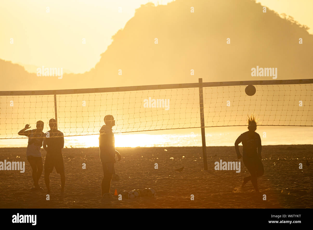 Am frühen Morgen Sport am Strand von Copacabana mit Silhouetten der Menschen Fuß volley Gegenlicht der goldenen Glanz der aufgehenden Sonne Stockfoto