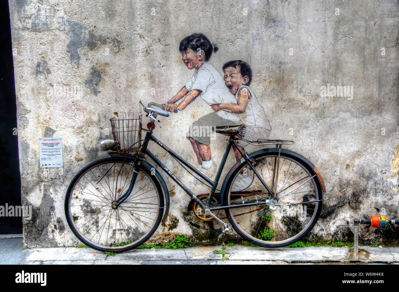 Kleine Kinder auf dem Fahrrad ist eine Wandmalerei von London gemalt - ausgebildete Künstler Ernest Zacharevic Stockfoto