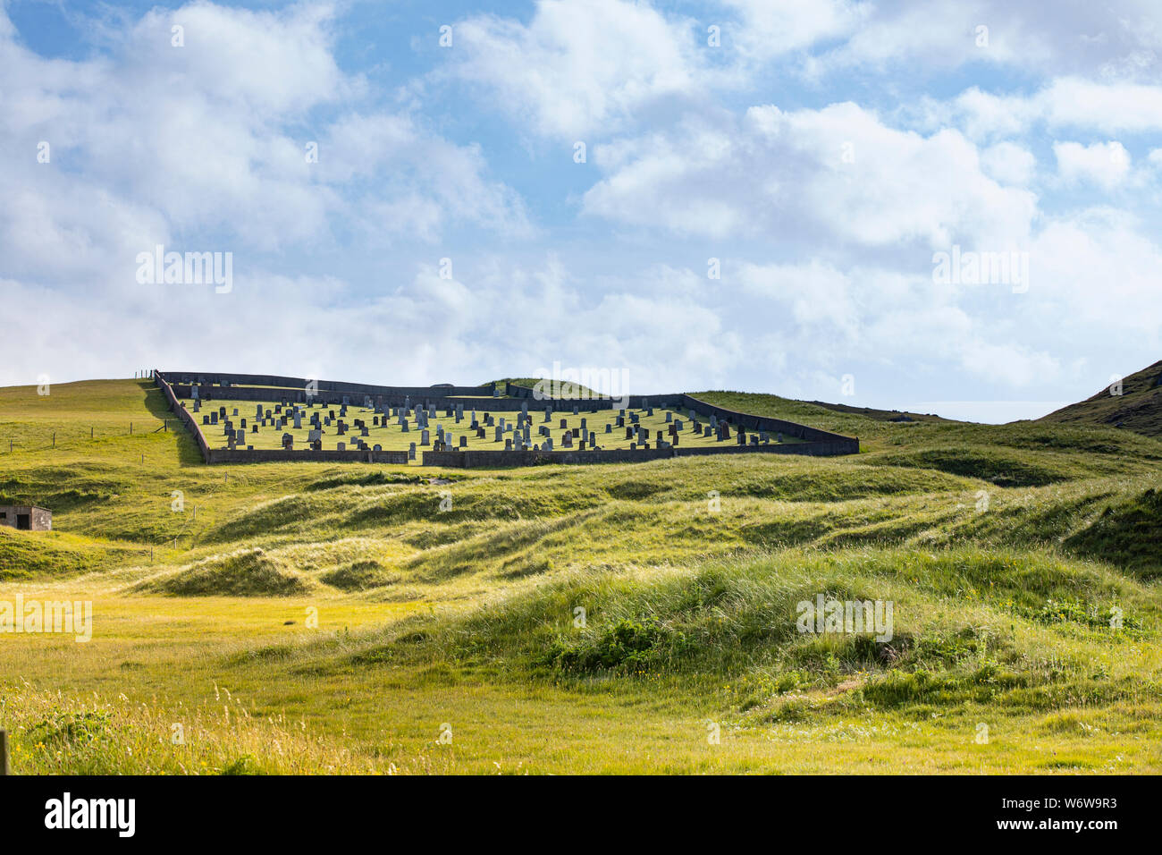 In Friedhof auf einem Hügel mit üppigen, grünen Gras in Schottland an einem sonnigen Tag mit einigen Wolken eingezäunt Stockfoto