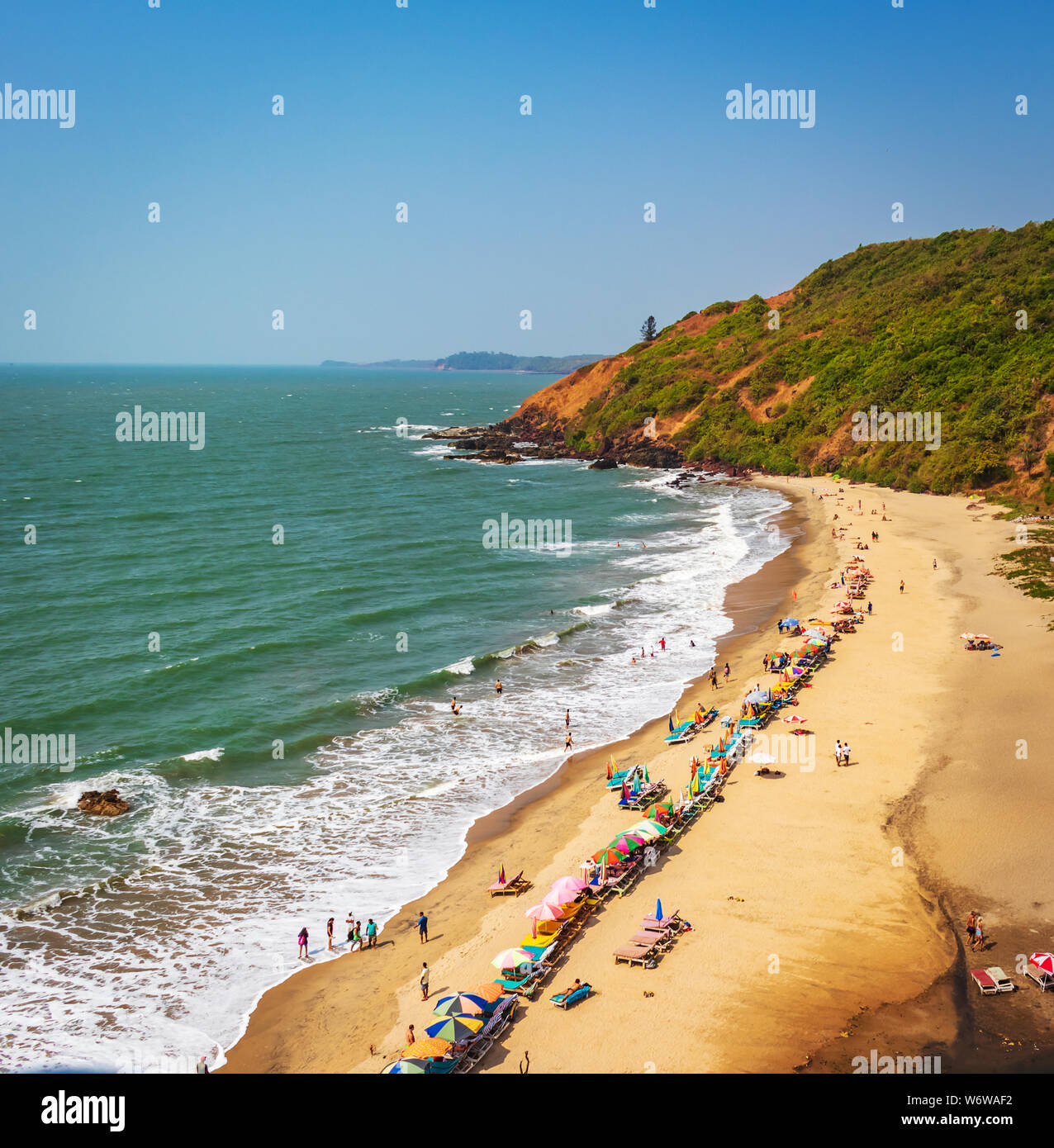 Blick von oben auf den Strand in Goa Indien Vagator Beach. Leute, die Sonnenbad am Strand auf Hütten Stockfoto