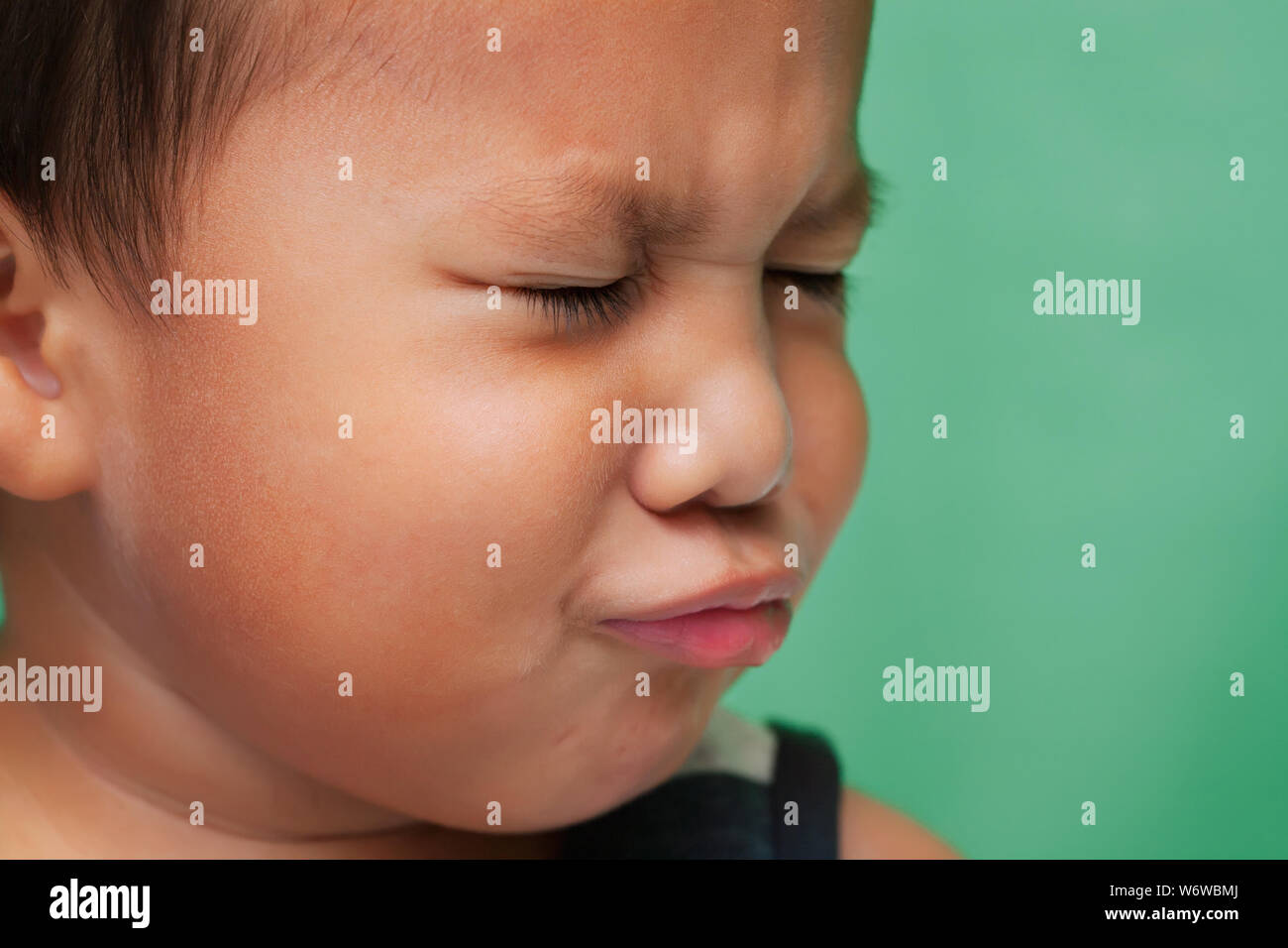 Kleines Kind mit Mimik, dass Traurigkeit zeigt oder Weinen. Stockfoto