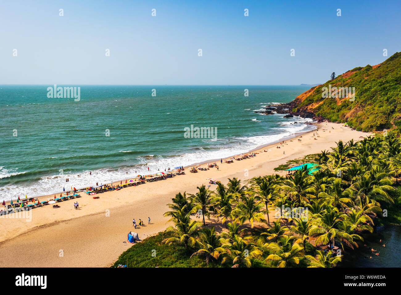 Blick von oben auf den Strand in Goa Indien Vagator Beach. Leute, die Sonnenbad am Strand auf Hütten Stockfoto