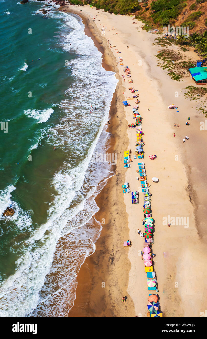 Blick von oben auf den Strand in Goa Indien Vagator Beach. Leute, die Sonnenbad am Strand auf Hütten Stockfoto