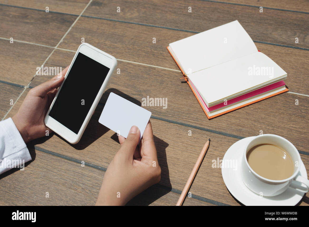 Nahaufnahme, Frau, Hand, die Kreditkarte und leerer Bildschirm Handy. Im Café sitzen Stockfoto