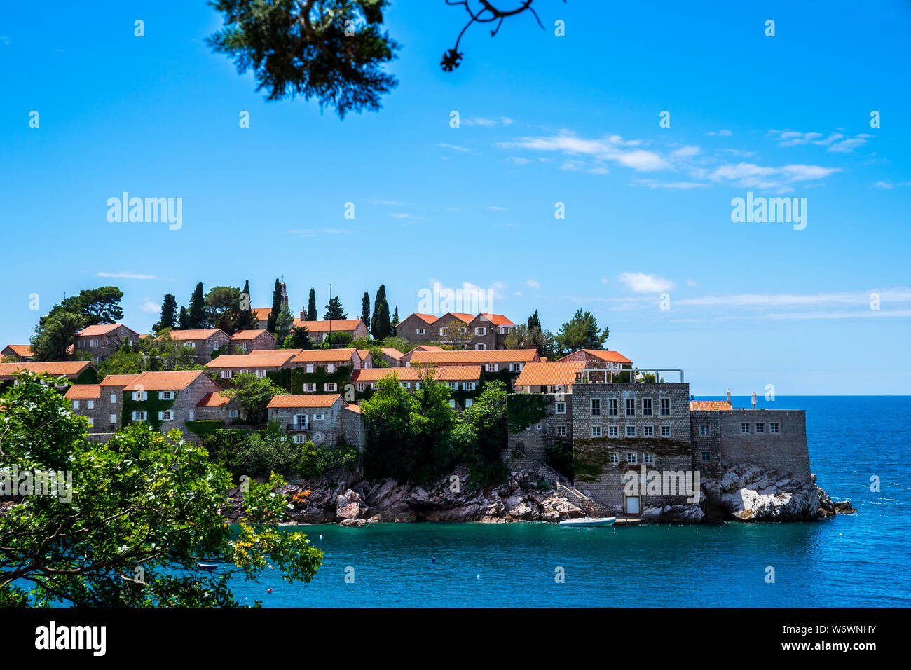 Montenegro, berühmten antiken Häuser aus Stein mit roten Dächern auf felsigen Insel Sveti Stefan im Sommer Urlaub in einer wunderschönen Natur Landschaft Stockfoto