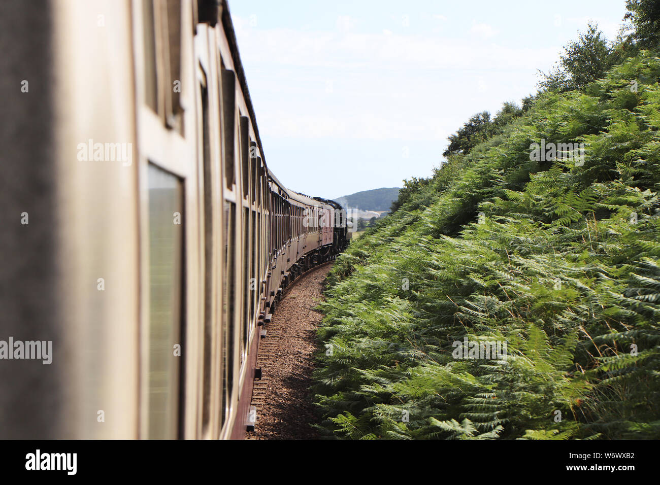 Blick entlang der Kutschen außerhalb einer Dampflok aus dem Fenster auf die North Norfolk Eisenbahn Poppy Linie Stockfoto
