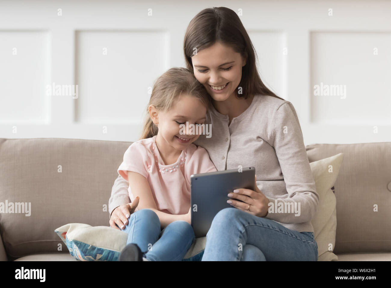Mutter und Tochter sitzen am Tisch Spaß mit Tablet Stockfoto