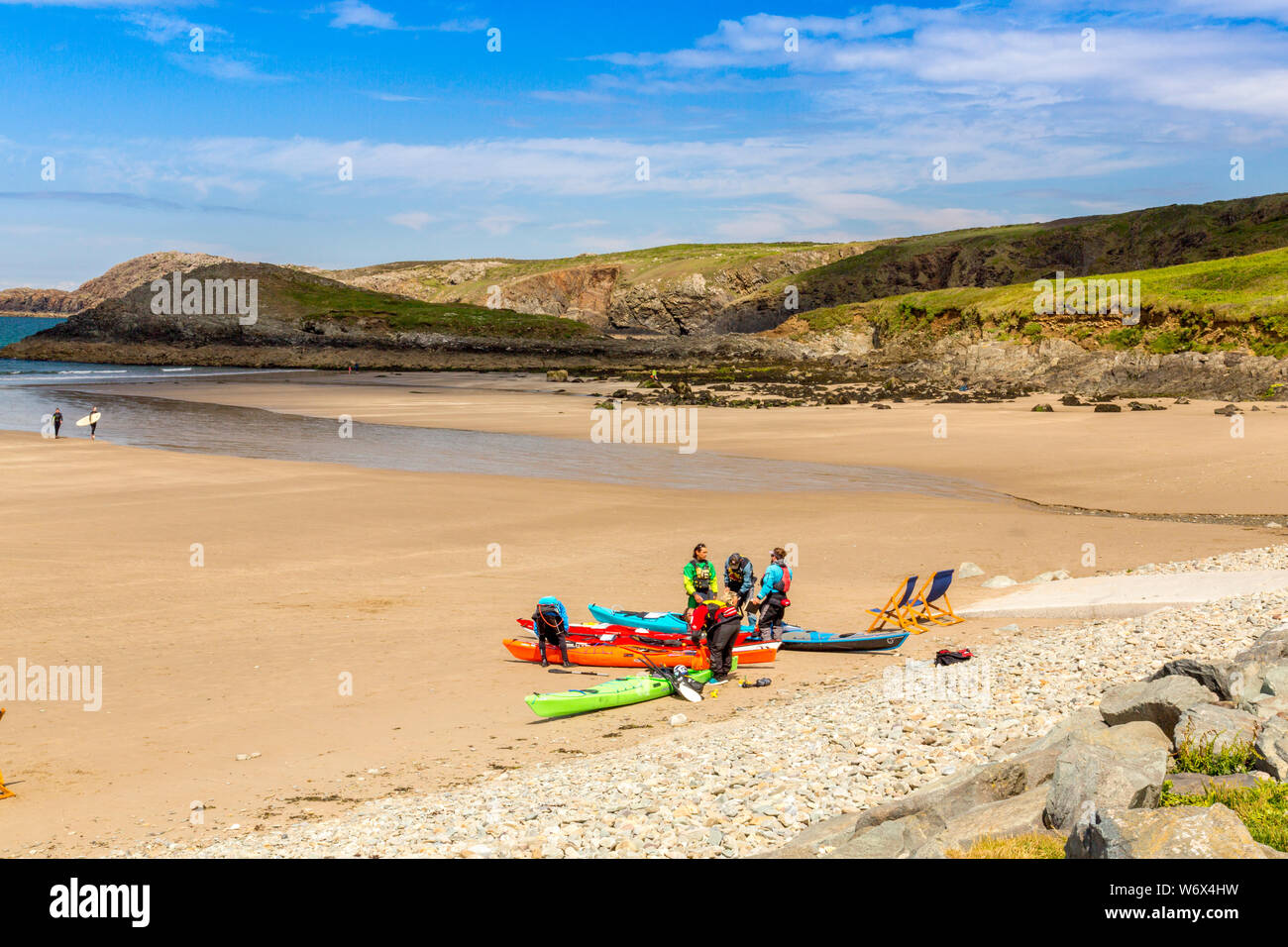 Sea kayakers an einem einsamen Strand an Whitesands Bay, Pembrokeshire Coast National Park, Wales, Großbritannien Stockfoto