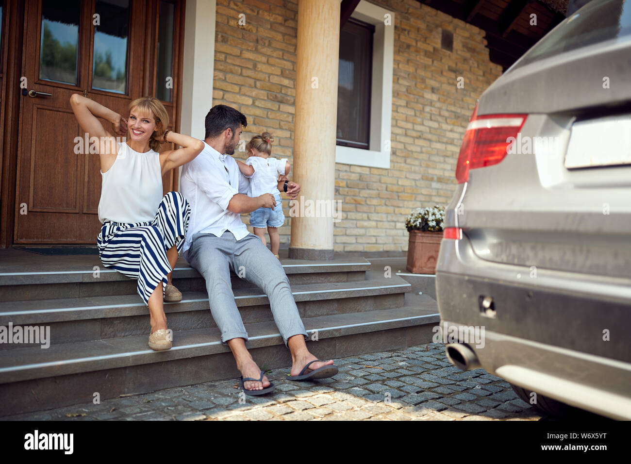 Kleines Kind mit Eltern genießen vor Wochenende Haus Stockfoto