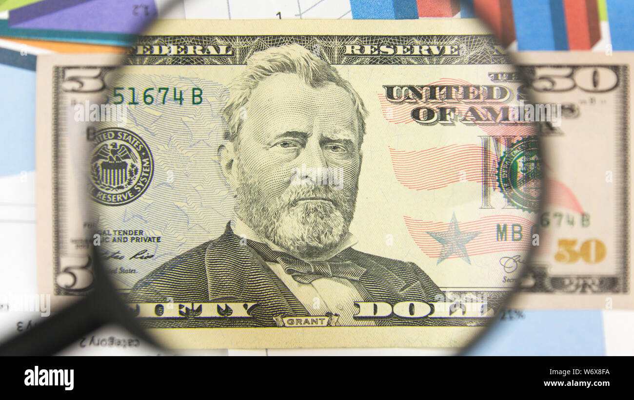 Close-up von fünfzig US-Dollar durch eine Lupe. Geschäft Hintergrund. Geld Forschung Konzept. Ansicht von oben Stockfoto
