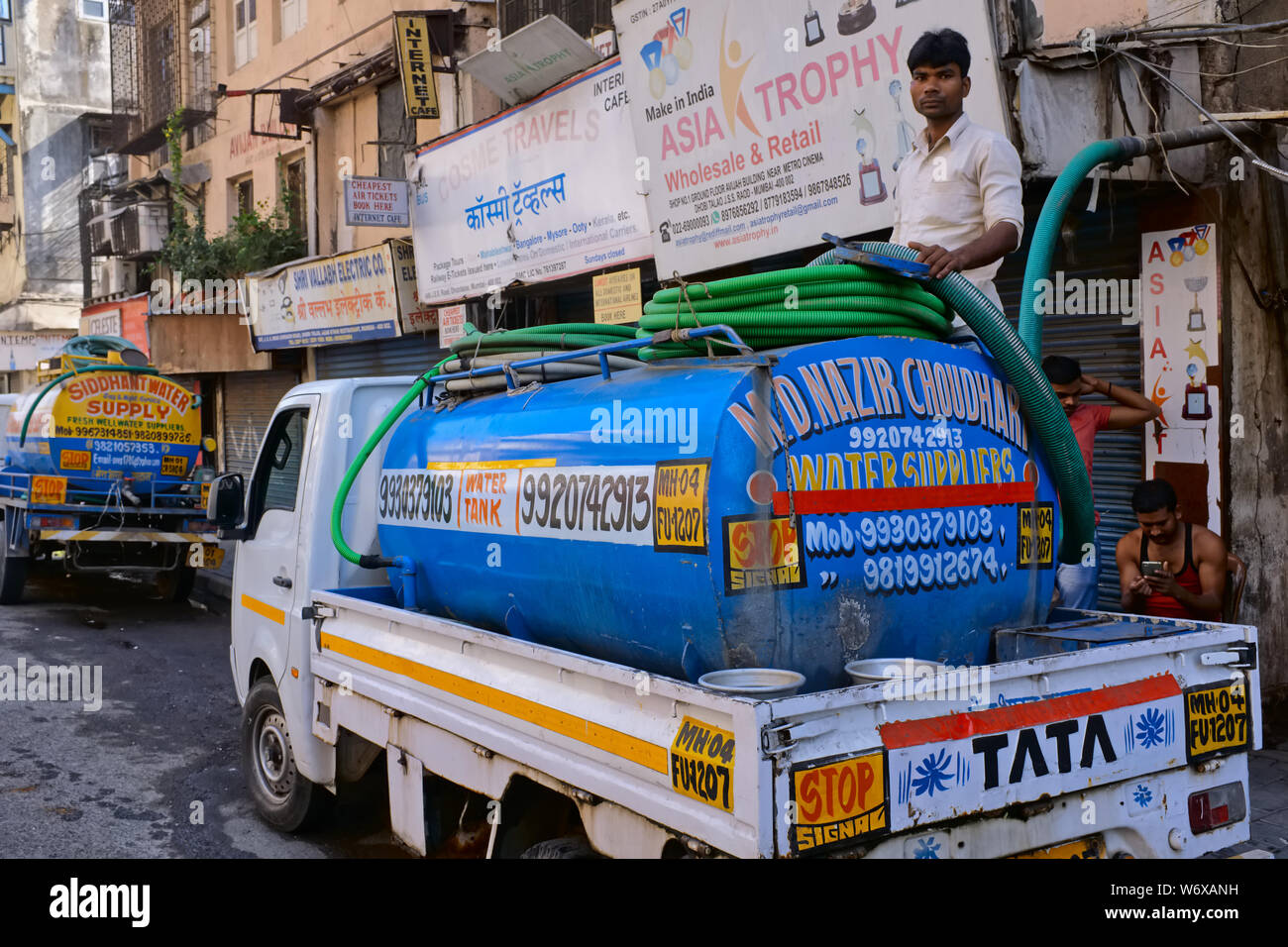 Wasser wird von einem Wasser Tank Wasser zu geschäftshäuser nicht an die Wasserversorgung angeschlossen zu liefern gepumpt; im Chira Bazar, Mumbai, Indien Stockfoto