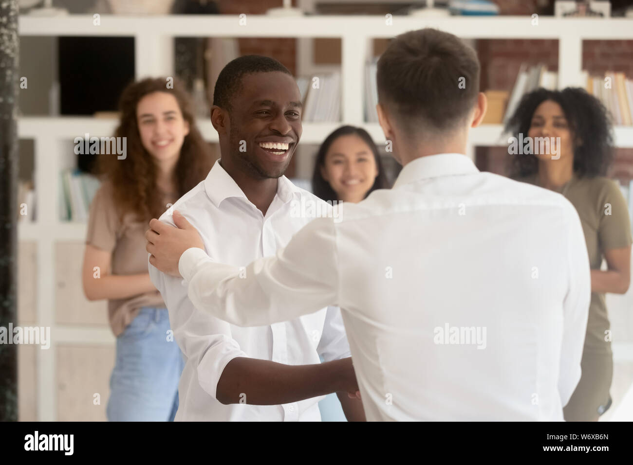 Diverse Firma Kopf schütteln Hände afrikanischen Mitarbeiter während Belohnung Stockfoto