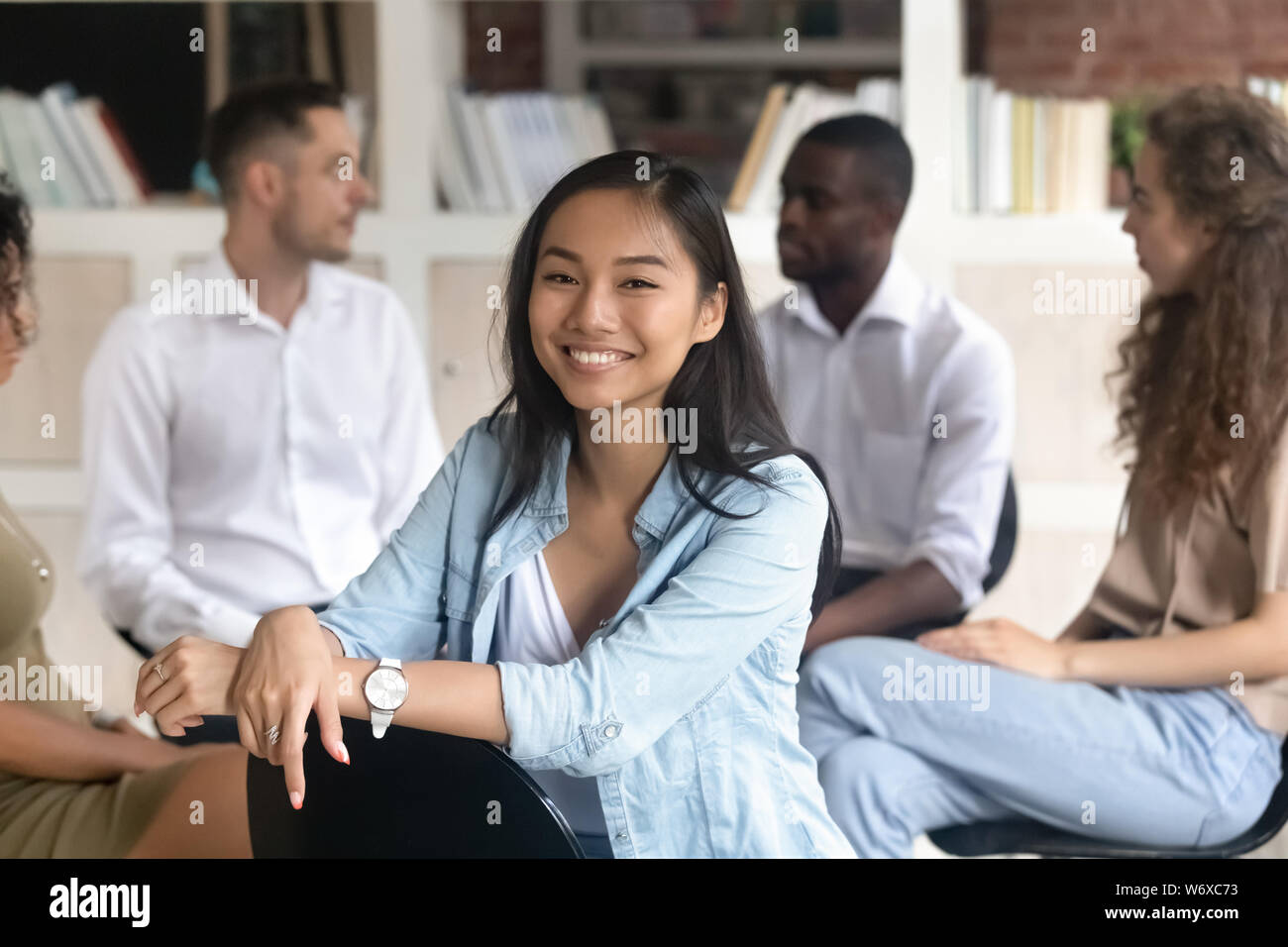 Asiatische sucht Ratgeber Pose auf Kamera während der Gruppe rehab Stockfoto