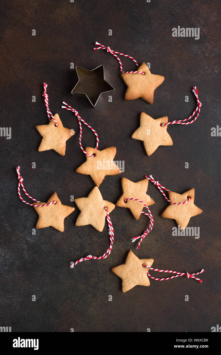 Weihnachten Hintergrund - Weihnachten sternförmigen Lebkuchen cookies mit roten Seilen und goldenen Kugeln für Christbaumschmuck auf rustikalen Hintergrund, t Stockfoto
