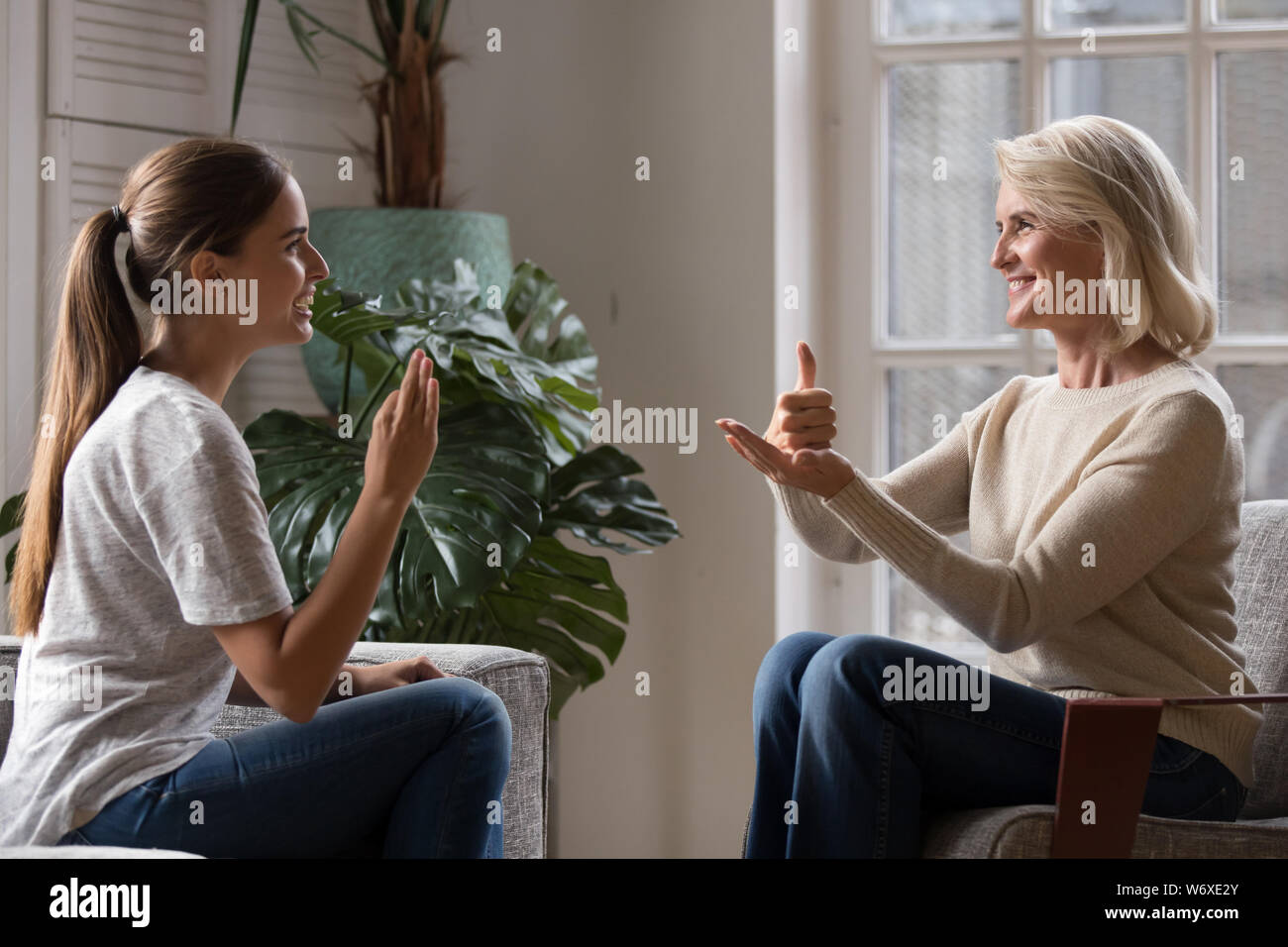 Aufgewachsen Tochter sprechen Sie mit älteren Mutter mit Zeichensprache Stockfoto