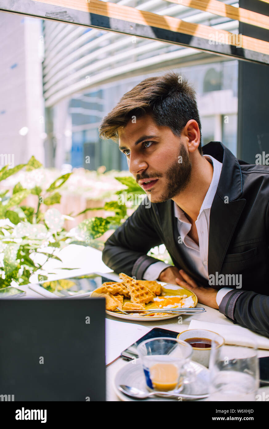 Geschäftsmann Frühstück haben und tut seine Arbeit am Laptop im Cafe Bar Stockfoto