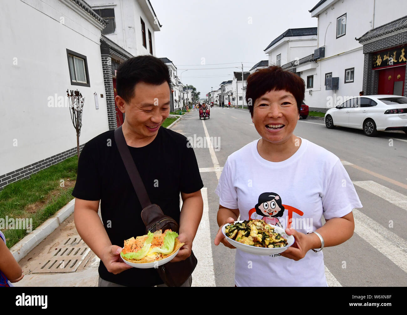 Hebi, der chinesischen Provinz Henan. 3 Aug, 2019. Zwei Dorfbewohner nehmen ihr Geschirr in den letzten Runden eines ländlichen Küche Wettbewerb in Gangpo Dorf Qibin Bezirk, Hebi, der Central China Provinz Henan, Aug 3, 2019. Die ländliche Küche Wettbewerb ist Teil der Vision Gangpo's Village ländlichen Tourismus zu profitieren Sie von der Nähe zum Stadtgebiet von Hebi entwickeln. Credit: Feng Dapeng/Xinhua/Alamy leben Nachrichten Stockfoto