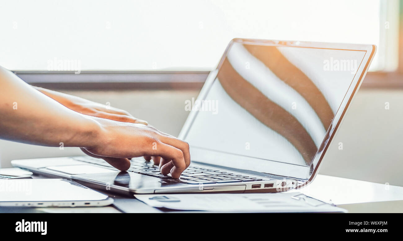 Die Hände der Männer in das stilvolle und elegante Notebook arbeiten an einem sonnigen Tag Stockfoto