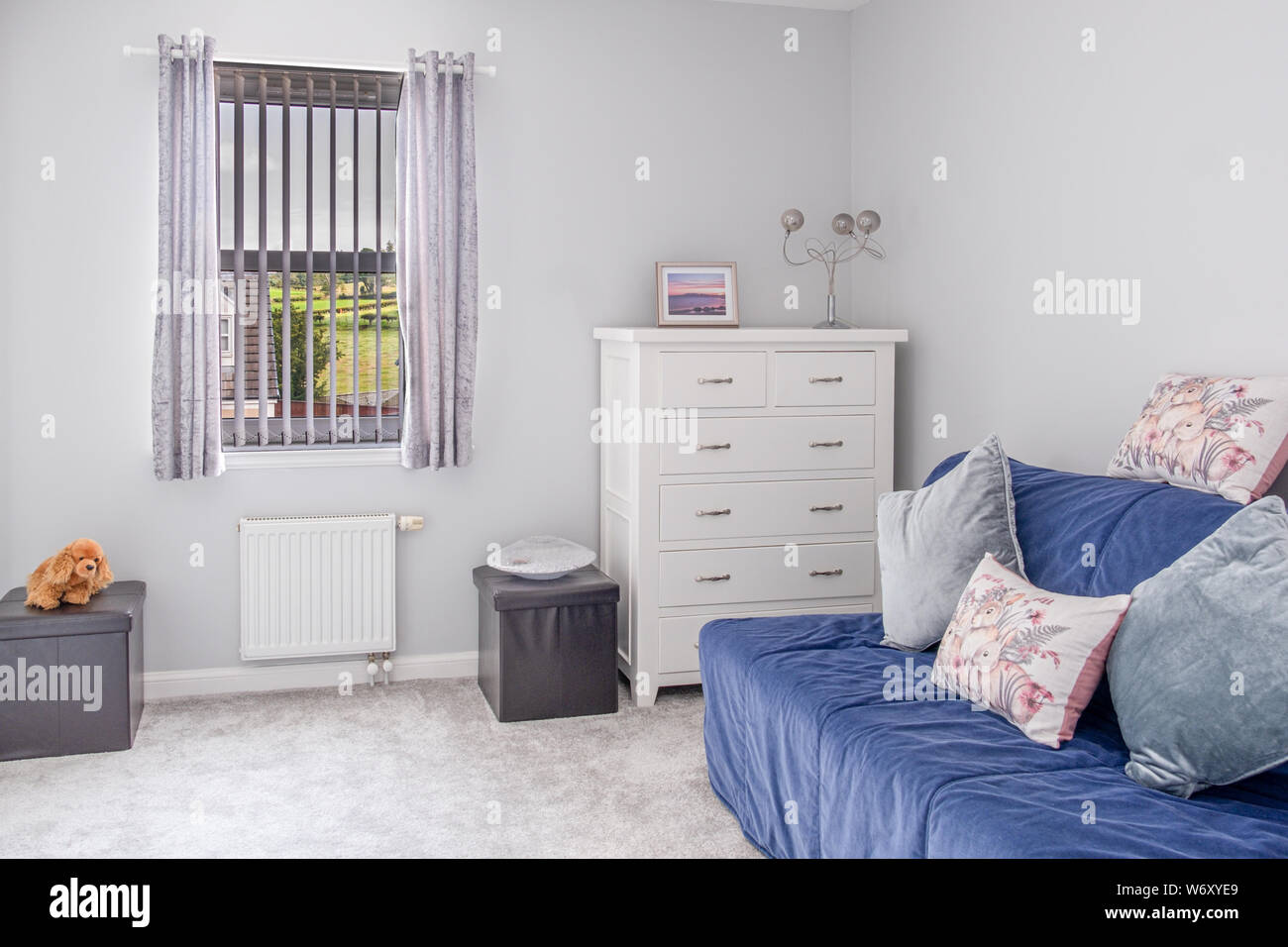 Kleine Ersatzraum in modernen Gehäuse Entwicklung mit einem Schlafsofa, Einrichtungsgegenständen, weiß lackiert Schubladen und die Wände in pollished peble gemalt. Stockfoto