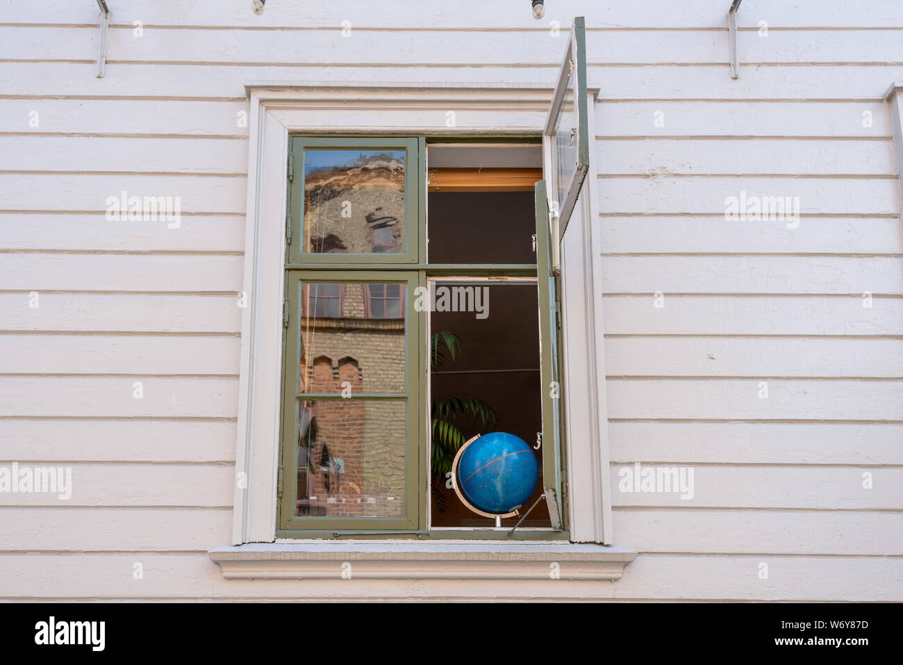 Göteborg, Schweden - 19 Juli 2019: In einem Fenster im Stadtteil Haga in Göteborg steht eine blaue Weltkugel, Schweden. Stockfoto