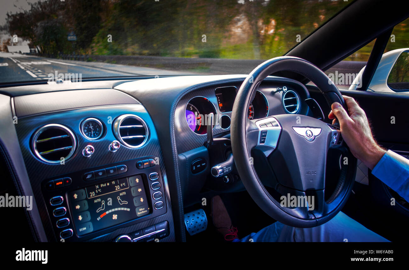 Autofahrer mit einer Hand am Lenkrad eines Bentley Continental GTC Supersport Stockfoto