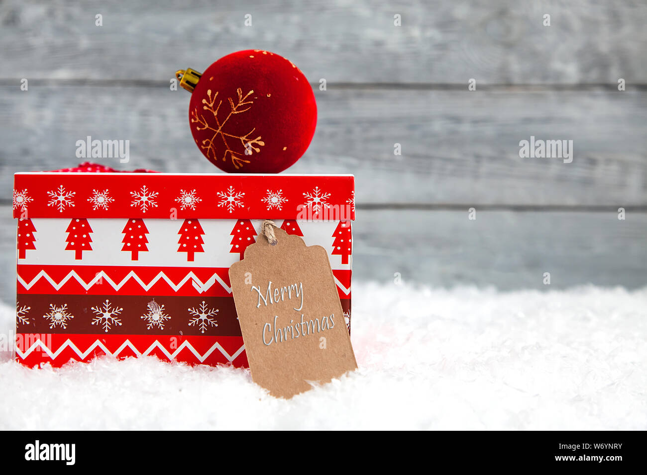 Red Christmas box auf Schnee und Holz- Hintergrund Stockfoto