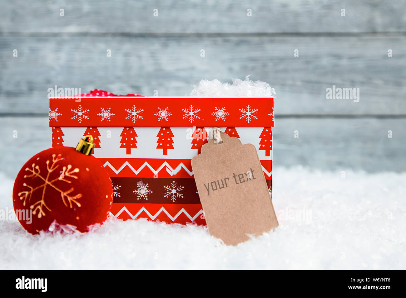 Red Christmas box auf Schnee und Holz- Hintergrund Stockfoto