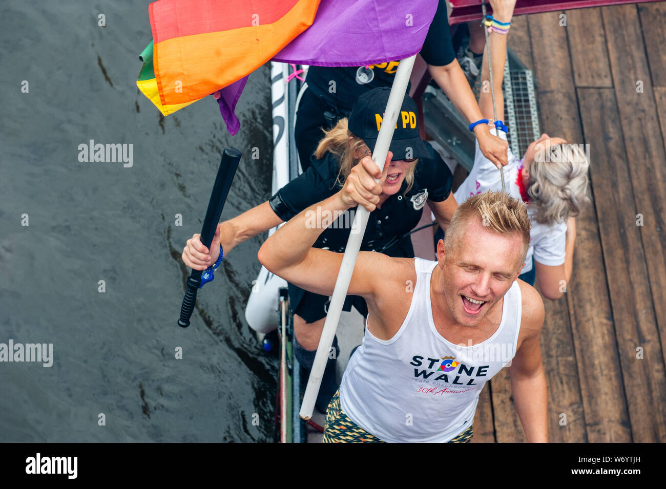 Ein Mann mit einem Stonewall t-shirt gesehen, riefen Parolen während der Parade. Die Canal Parade ist, was Amsterdam Gay Pride berühmt ist. Es ist die Krone auf Ihre zwei Wochen fest, dass mehr als 200 Veranstaltungen bietet. Die Boote starten im Scheepvaart Museum auf dem östlichen Teil der Innenstadt in Richtung Amstel Fluß. Die Schwimmer von dort weiter unter Berücksichtigung der Prinsengracht zur Westerdok. Der Canal Parade beginnt um 12.30 Uhr und dauert den ganzen Nachmittag. Rund 80 Boote verschiedener Organisationen und gemeinnützige Organisationen beteiligen sich an der Veranstaltung. Stockfoto