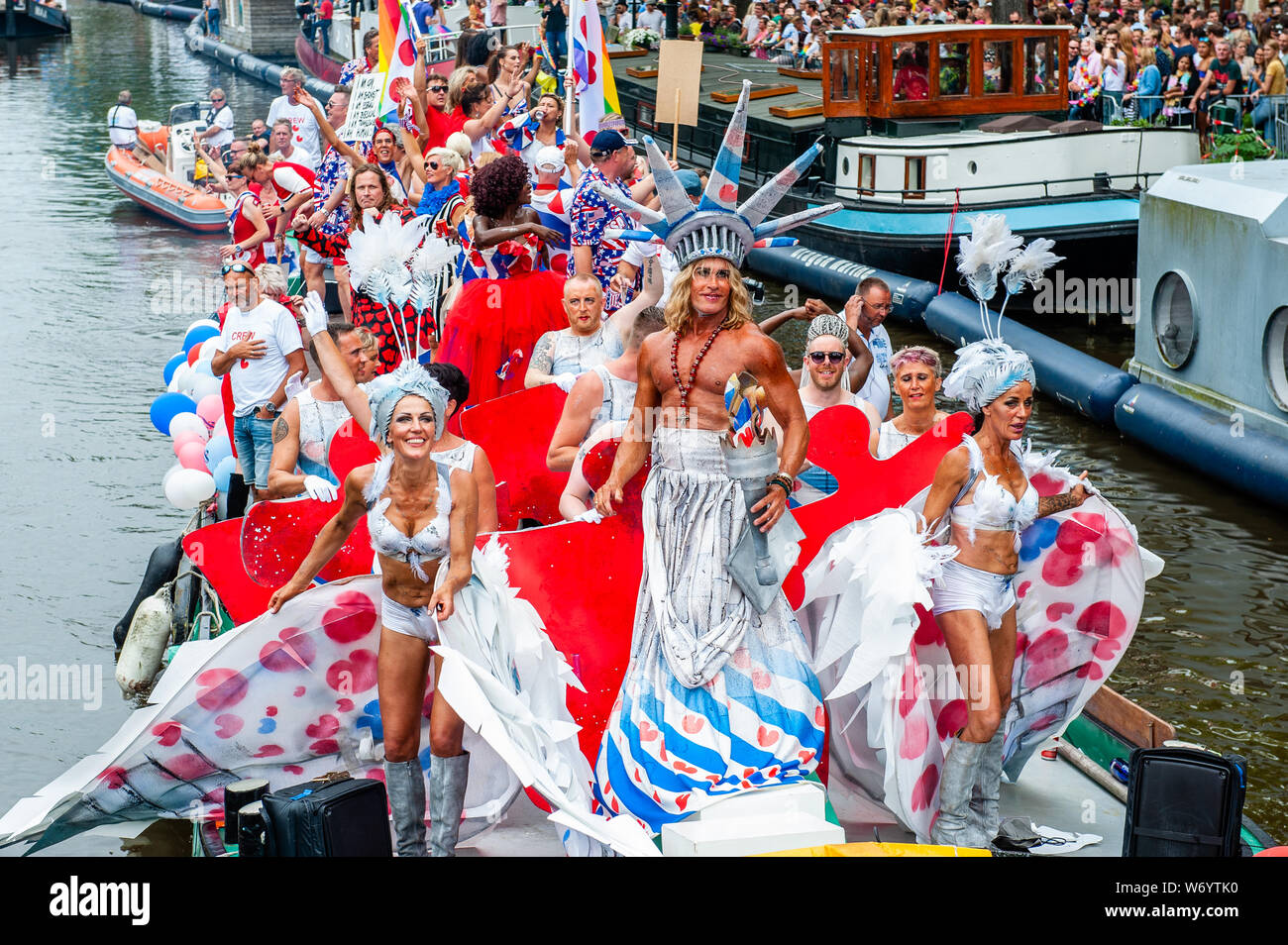 Ein Mann wird gesehen, eine Statue der Freiheit Kostüm auf einem der Boote  während der Parade. Die Canal Parade ist, was Amsterdam Gay Pride berühmt  ist. Es ist die Krone auf Ihre