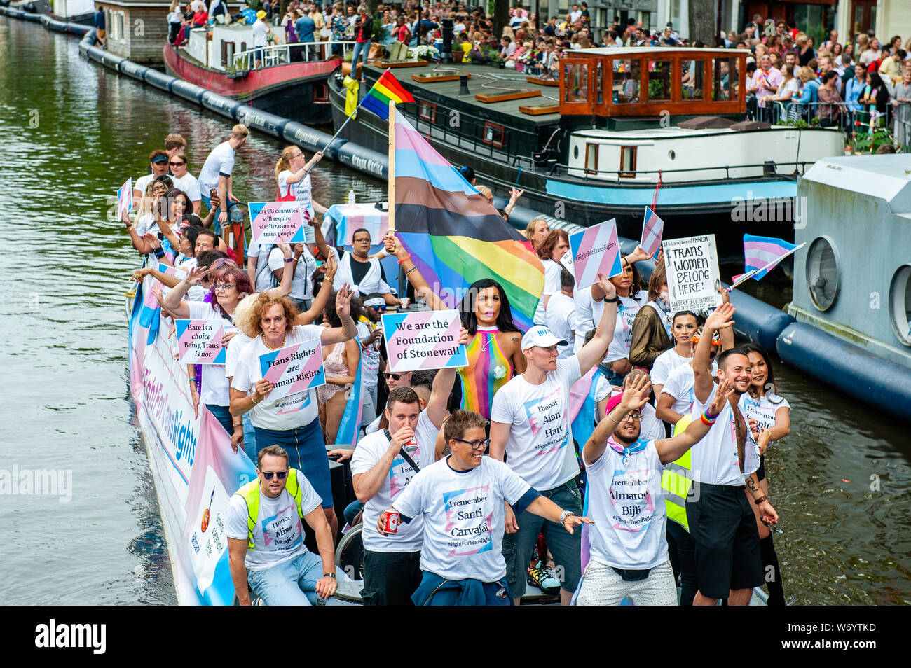 Ein Boot der Transsexuellen gesehen werden Plakate während der Parade. Die Canal Parade ist, was Amsterdam Gay Pride berühmt ist. Es ist die Krone auf Ihre zwei Wochen fest, dass mehr als 200 Veranstaltungen bietet. Die Boote starten im Scheepvaart Museum auf dem östlichen Teil der Innenstadt in Richtung Amstel Fluß. Die Schwimmer von dort weiter unter Berücksichtigung der Prinsengracht zur Westerdok. Der Canal Parade beginnt um 12.30 Uhr und dauert den ganzen Nachmittag. Rund 80 Boote verschiedener Organisationen und gemeinnützige Organisationen beteiligen sich an der Veranstaltung. Stockfoto