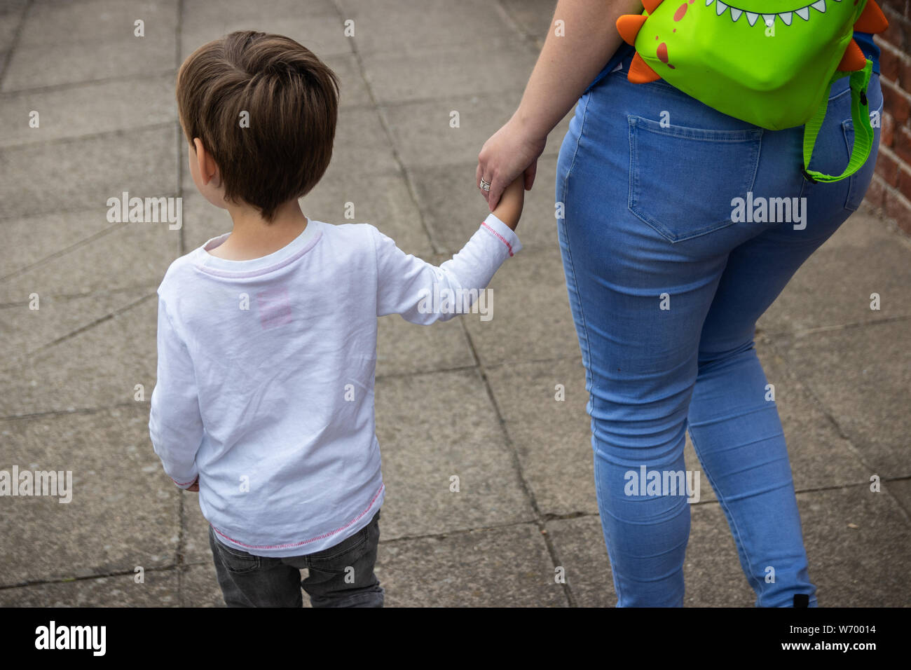 Hände halten eine Mutter mit ihrem kleinen Kind Stockfoto